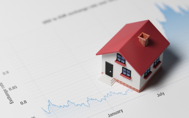 miniature house on a blue financial grap