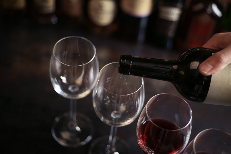 Bartender pours a glass of red