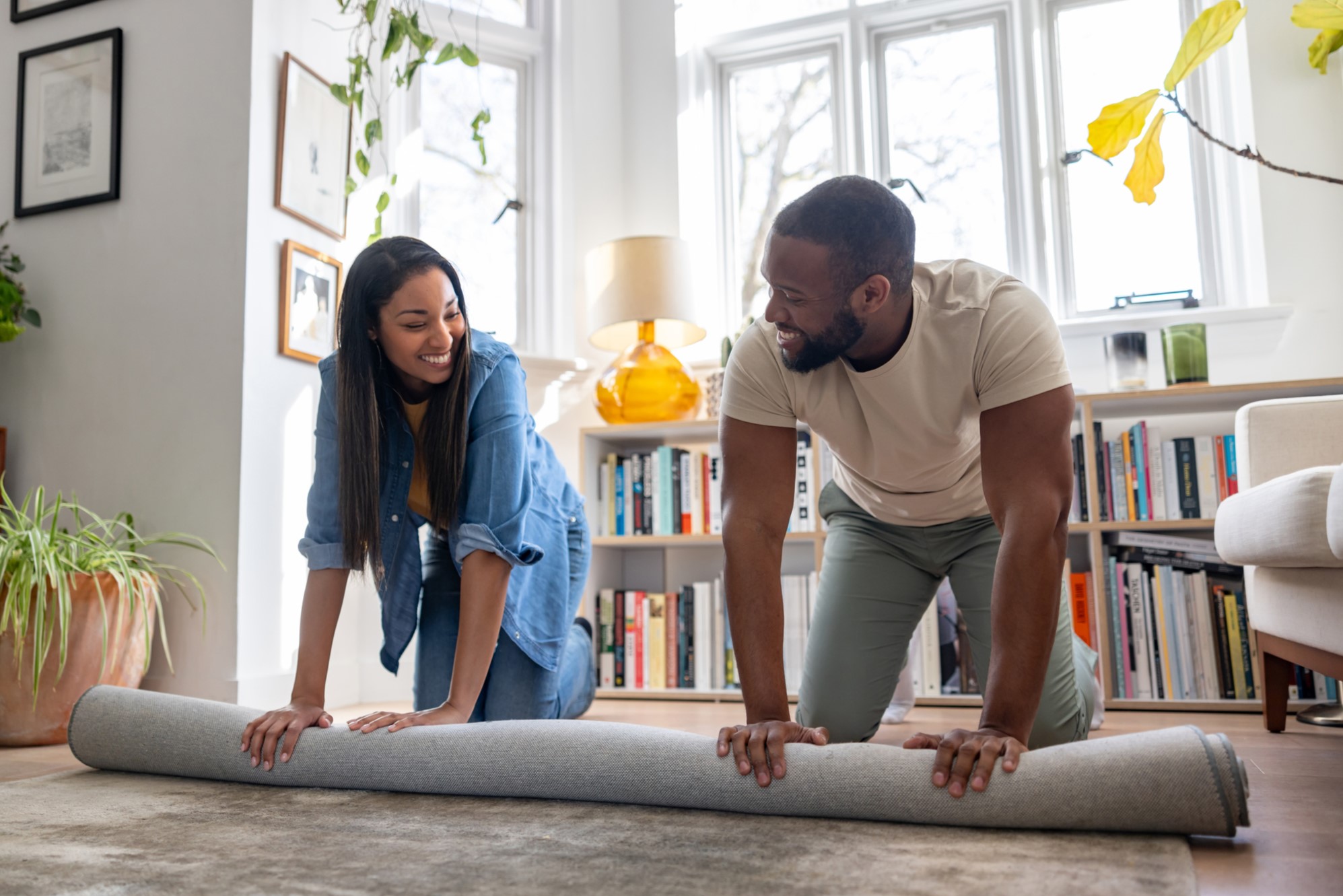happy couple rolling up a carpet in their laguna beach home